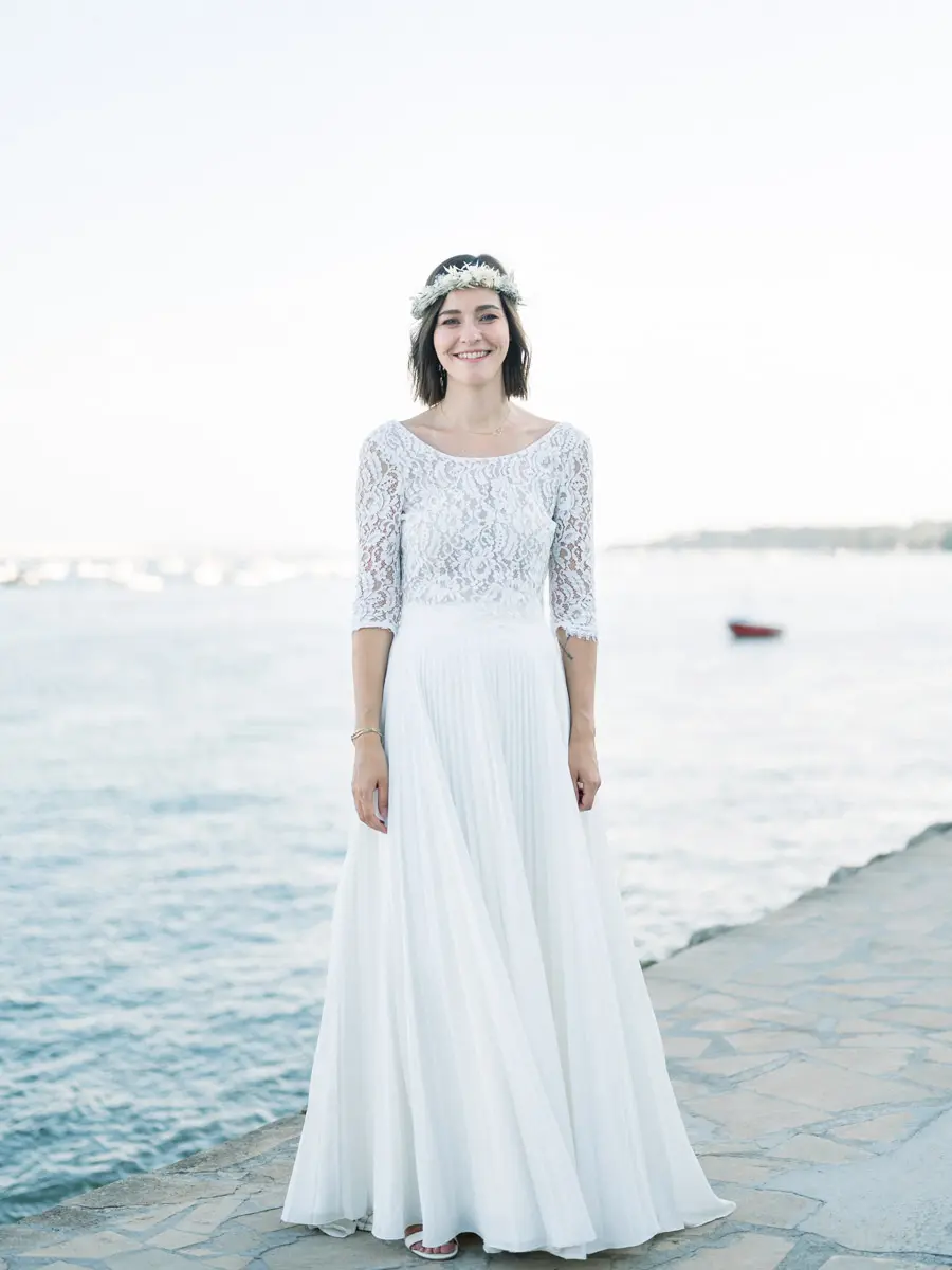 mariée de face avec la mer dans son dos