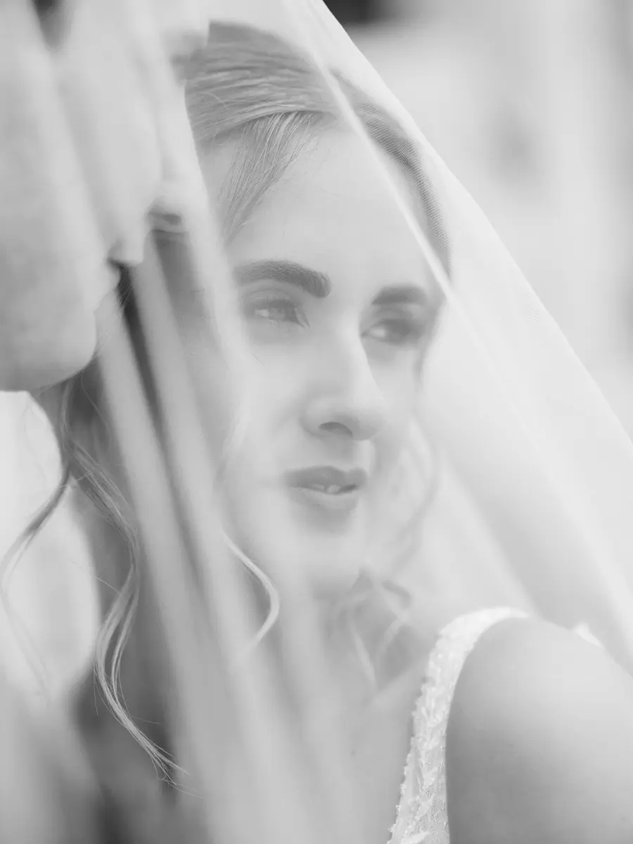 Portrait de mariée en noir et blanc sous voile, photographie de mariage éditoriale et élégante