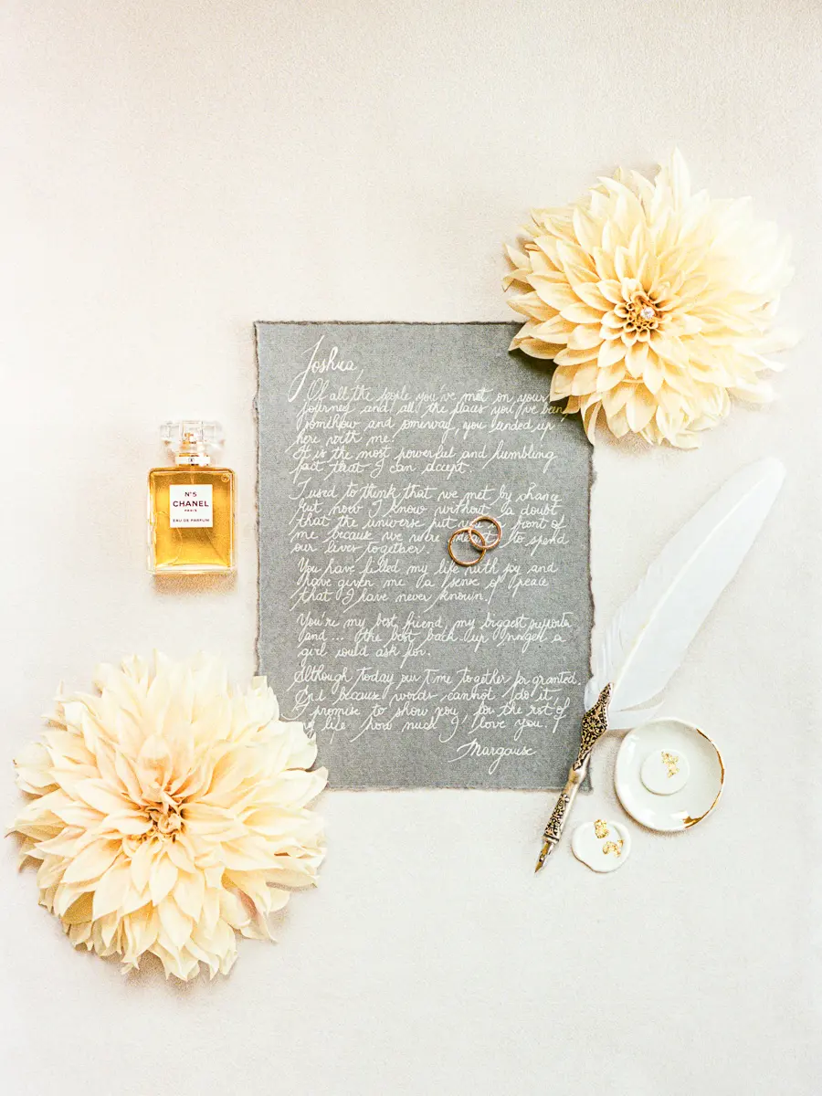 flat lay de détails de mariage avec alliances parfum et papeterie photographie de mariage éditoriale