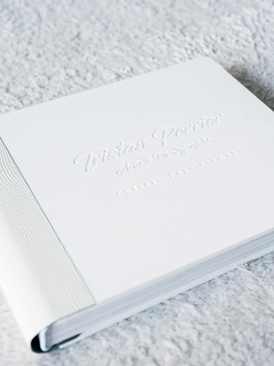 Livre photo blanc de mariage de la gamme Luxe avec une couverture en cuir sur la tranche et au verso et une plaque en plexiglas avec gravure personnalisée