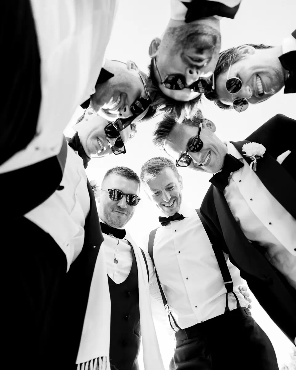 Group of groomsmen during wedding getting ready captured in black and white editorial photography