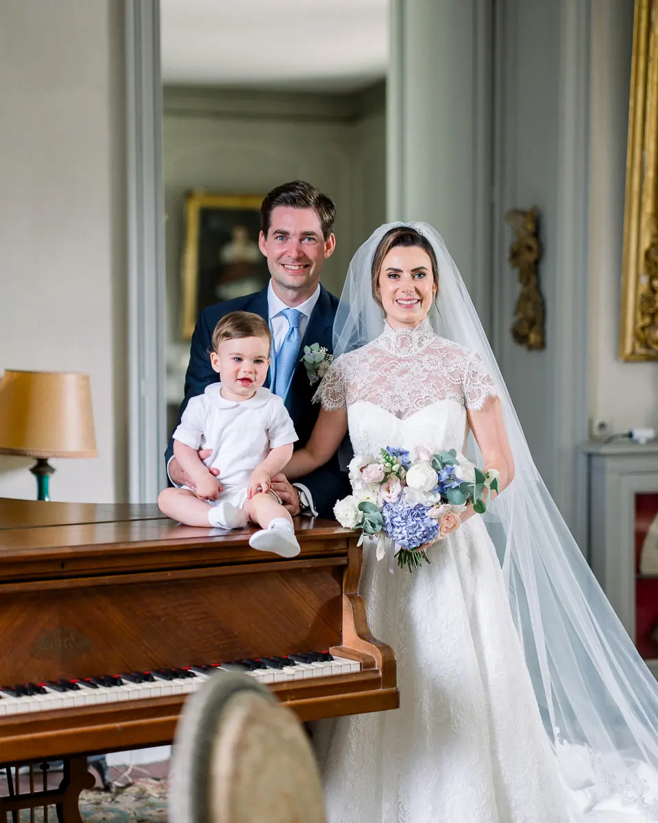 Couple de mariés avec leur enfant lors des préparatifs – moment naturel et élégant en intérieur de leur château